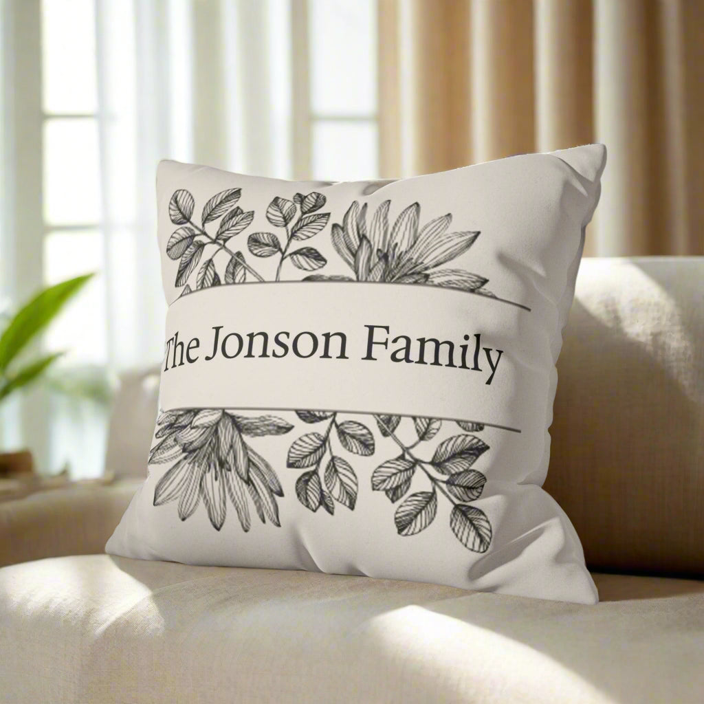 Decorative pillow with 'The Jonson Family' text and leaf designs on a gray couch.