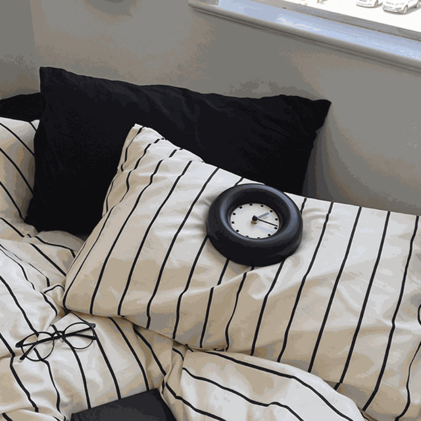 Modern ivory beige stripe duvet cover set with black vertical lines and black pillows on bed