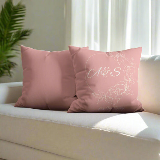 Pink pillows with monogram on a gray sofa