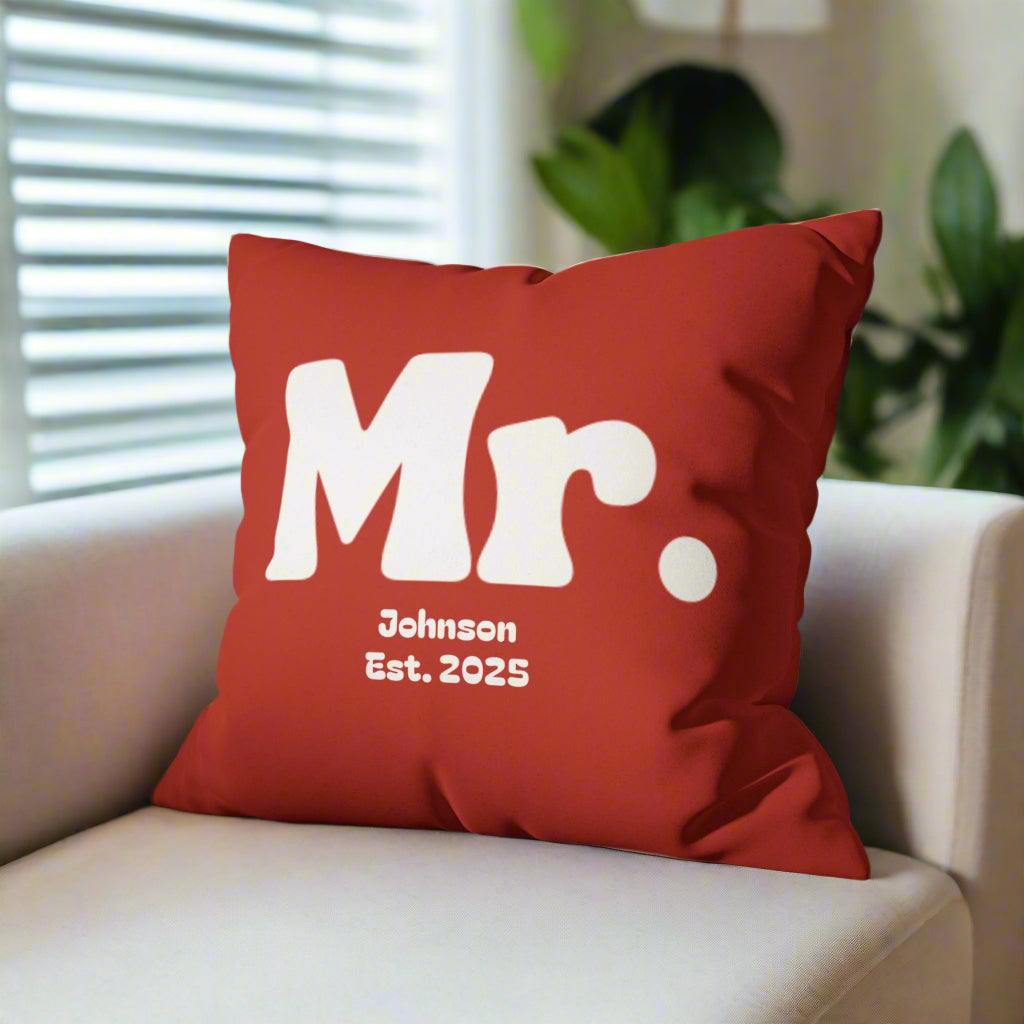 Red pillow with 'Mr. Johnson Est. 2025' text on a gray couch