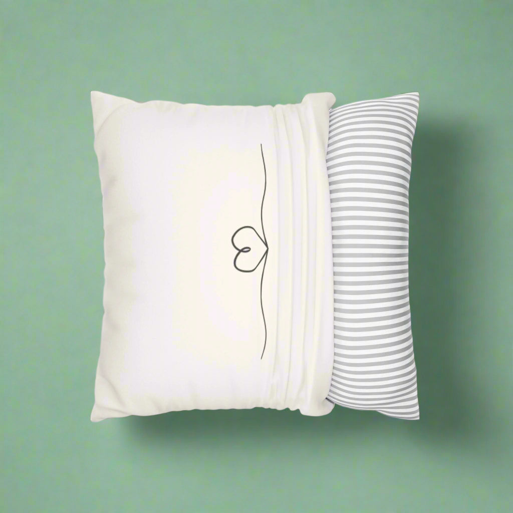White pillow with a minimalist design and a striped pillow on a white background