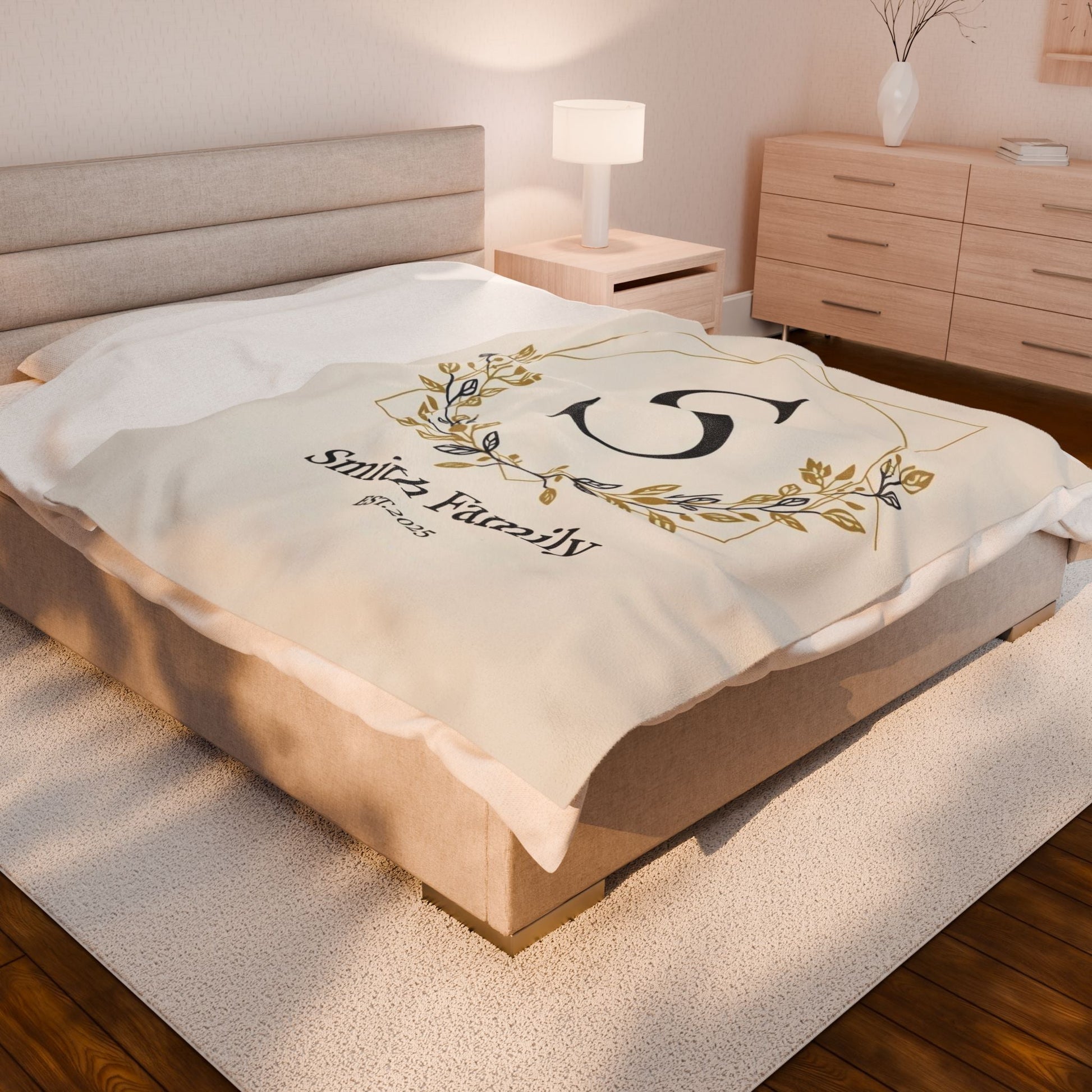 Personalized Family Monogram fleece blanket with custom names and elegant gold wreath design on a cozy bed throw for couples' anniversary or wedding gift