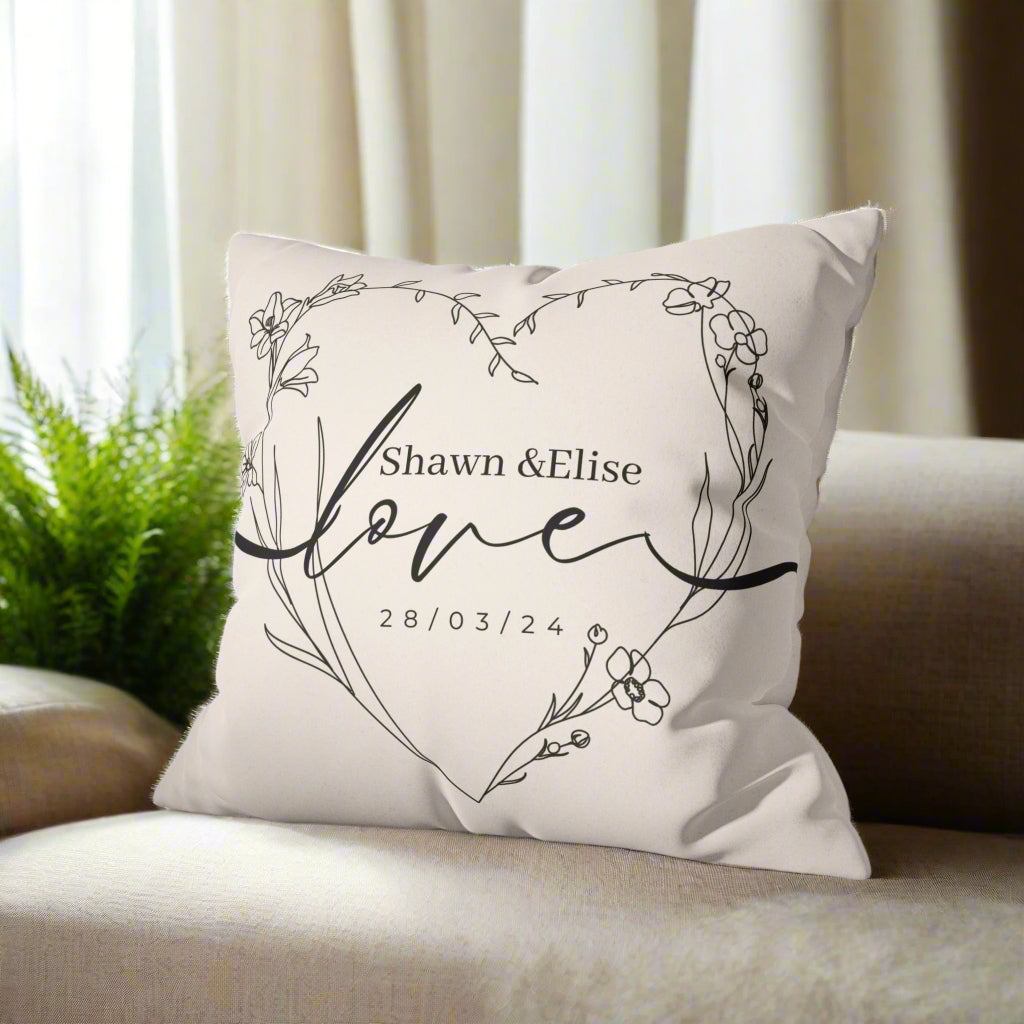 Decorative pillow with floral design and text on a gray couch