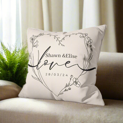 Decorative pillow with floral design and text on a gray couch