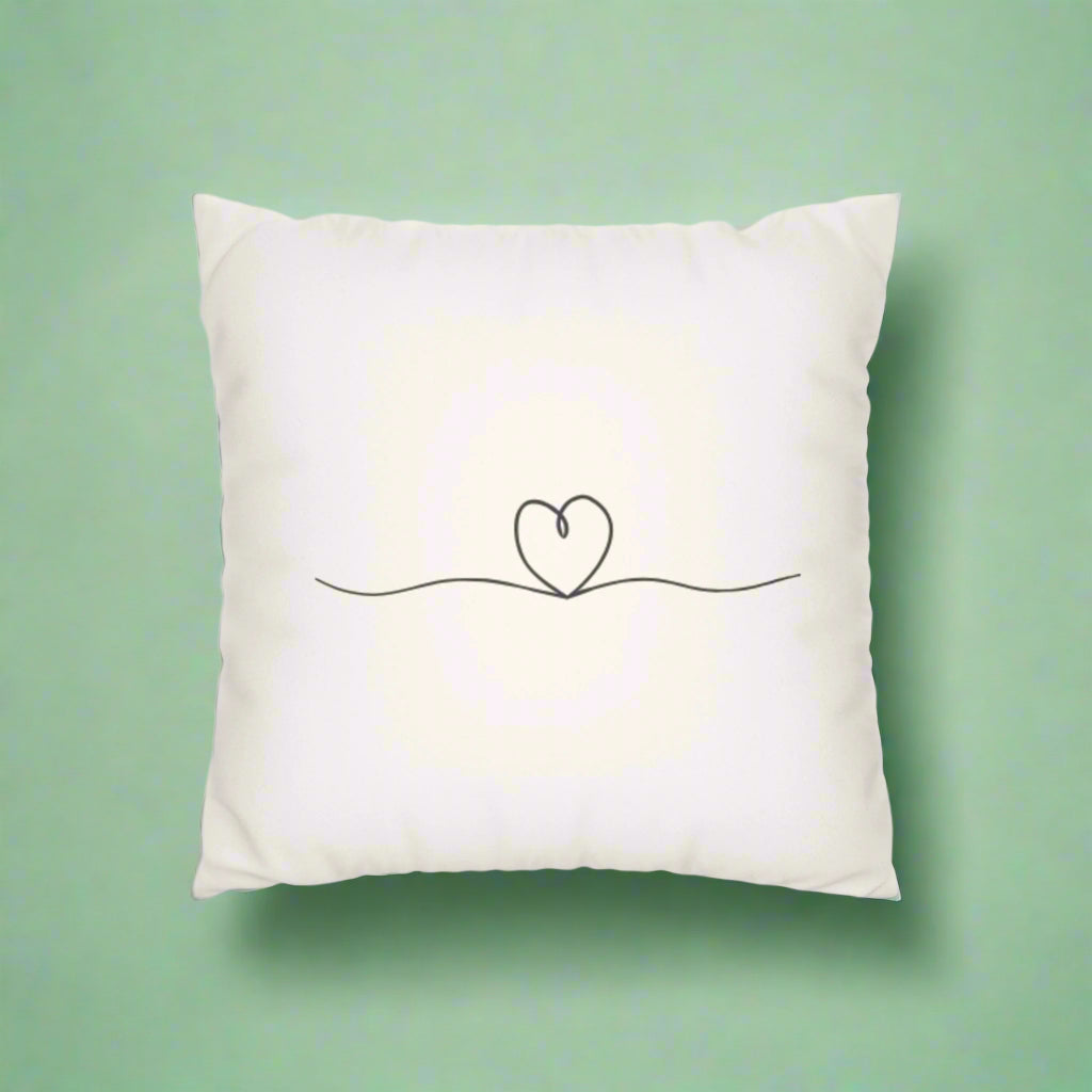 White pillow with a minimalist heart design on a white background