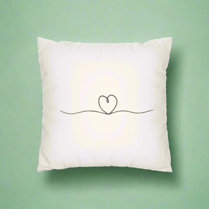 White pillow with a minimalist heart design on a white background