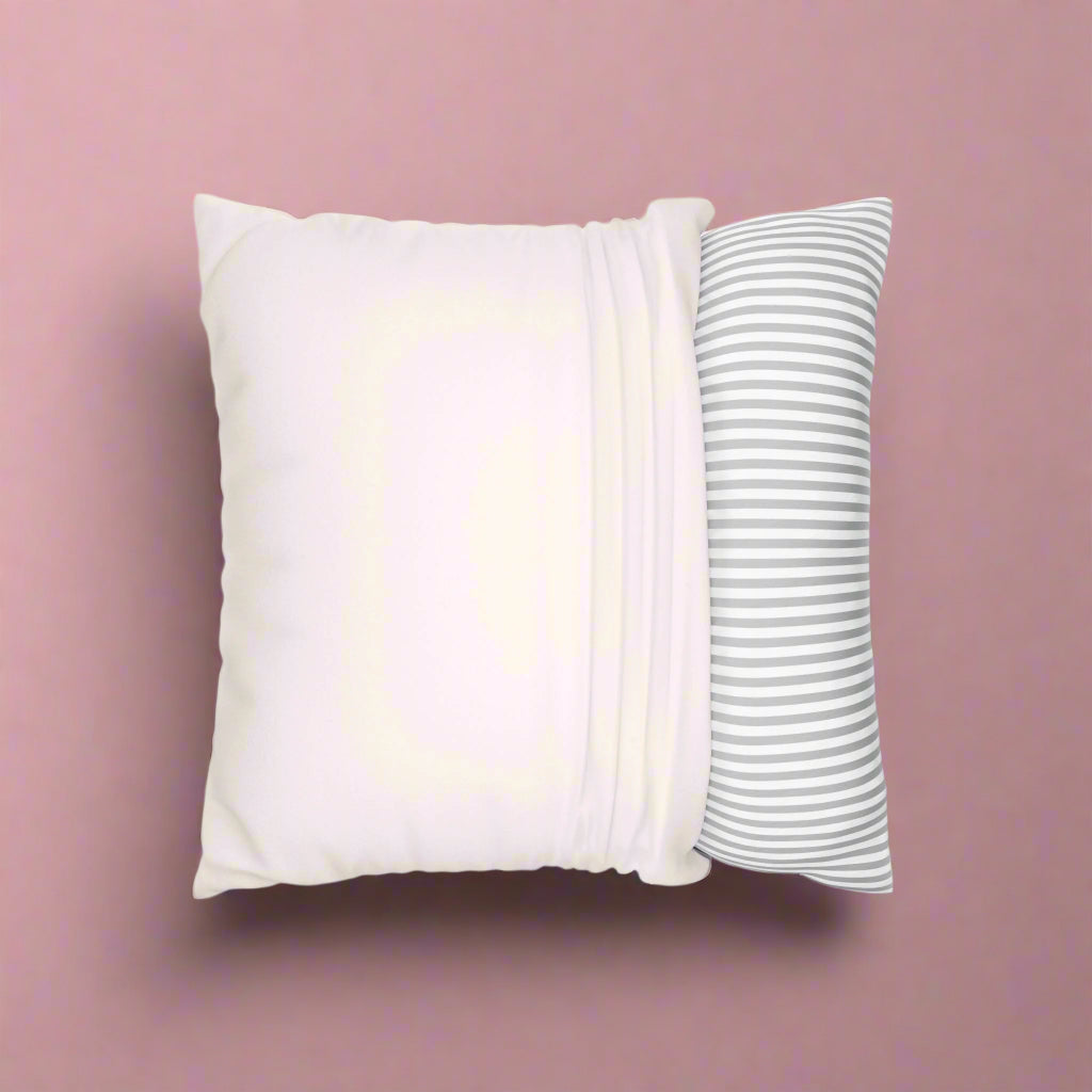 Two pillows, one plain white and one with gray stripes, on a white background