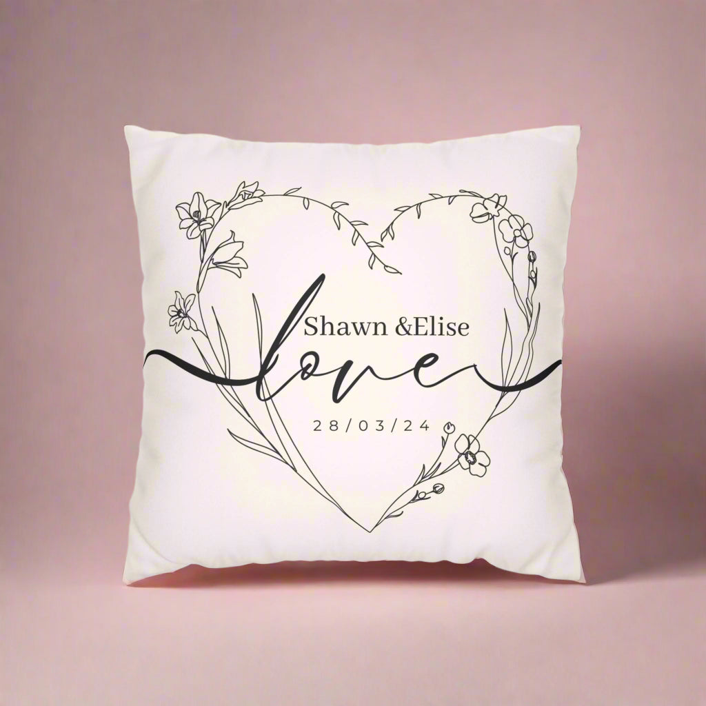 Decorative pillow with floral heart design and personalized text on a white background