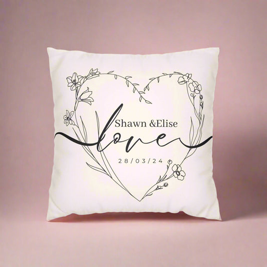Decorative pillow with floral heart design and personalized text on a white background