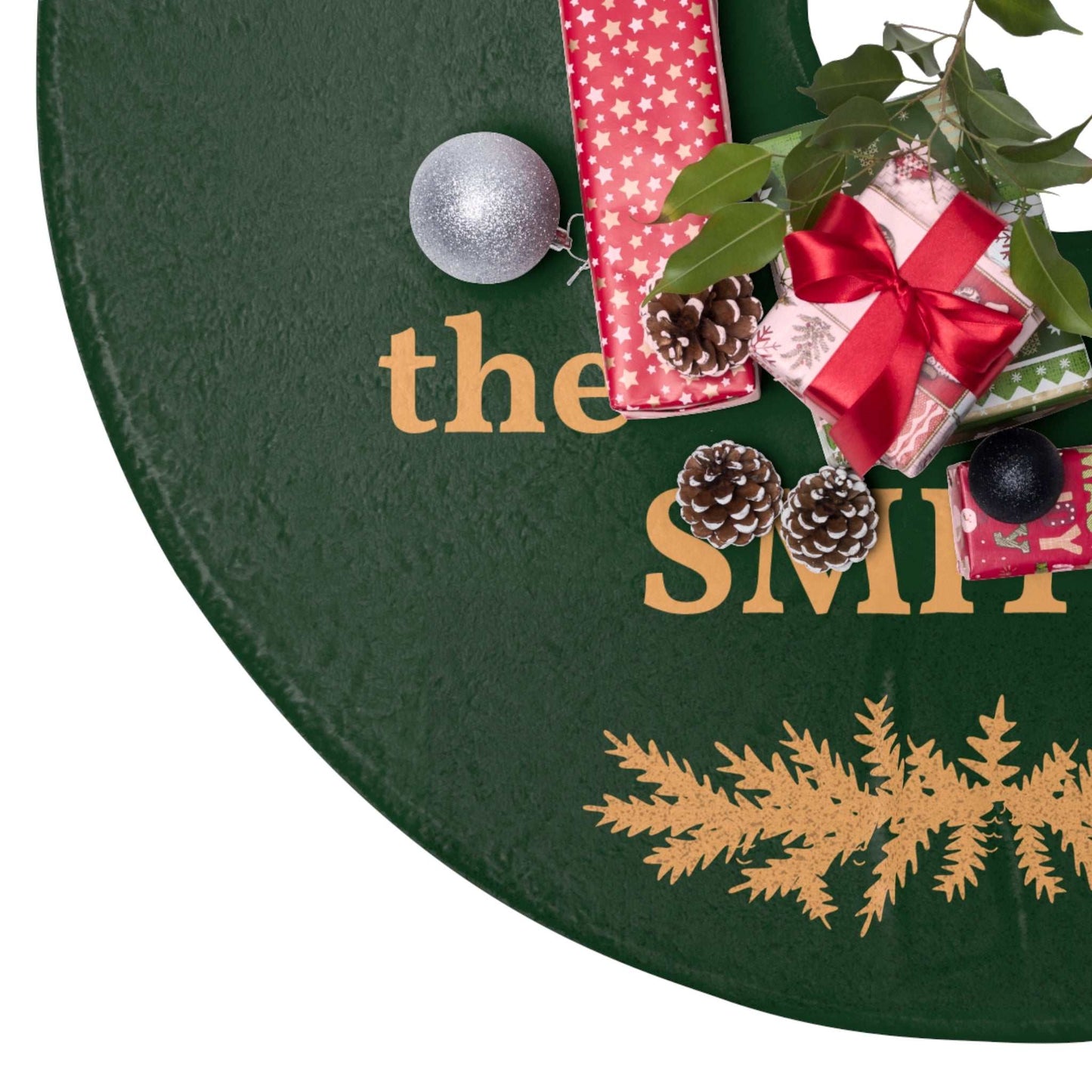 Personalized Christmas tree skirt in green fleece with custom family name and festive design under decorated Christmas tree with gifts and pinecones