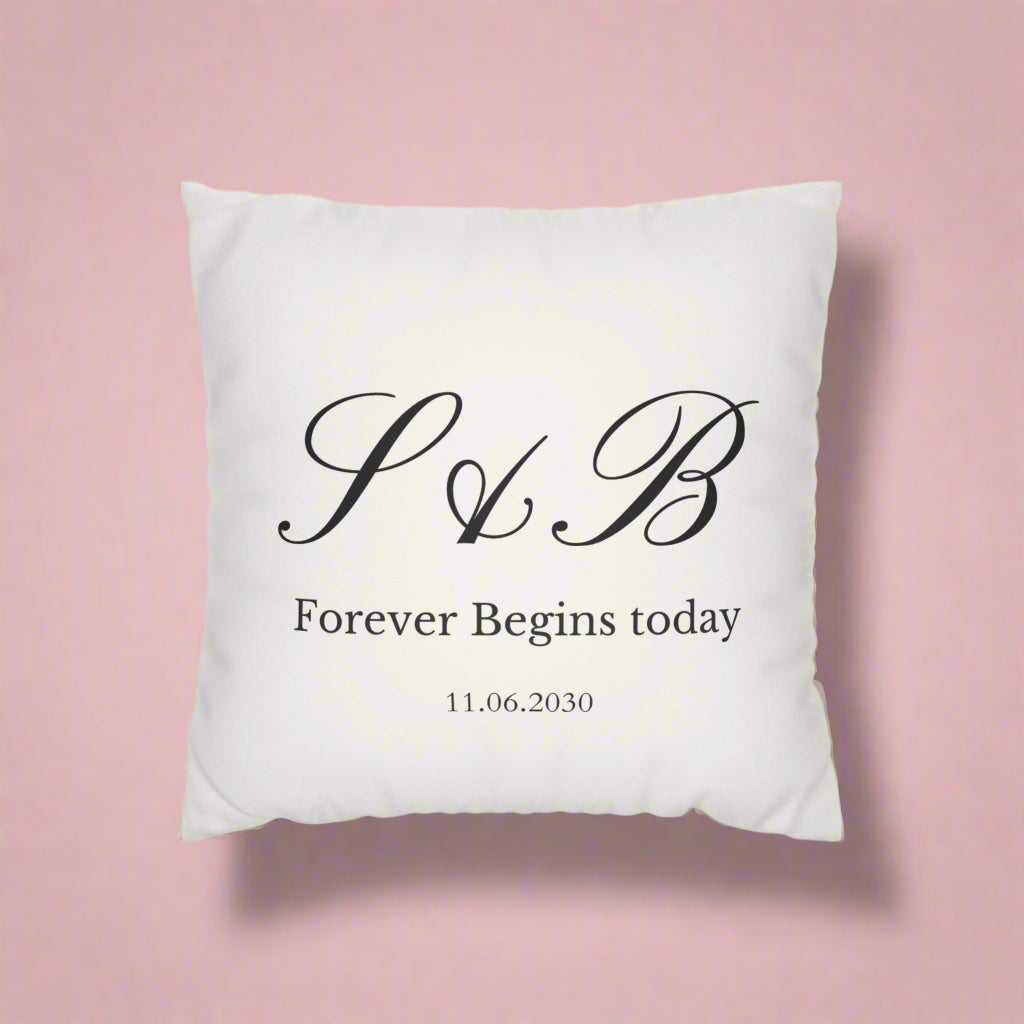 White pillow with black monogram and text on a white background