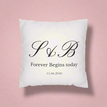 White pillow with black monogram and text on a white background