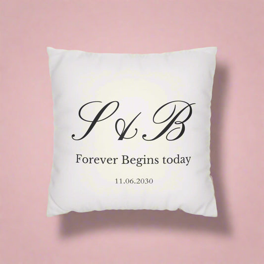 White pillow with black monogram and text on a white background