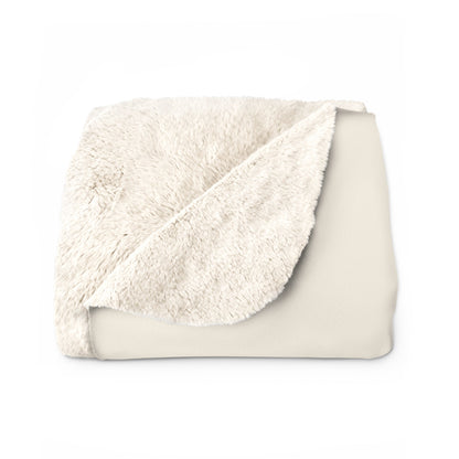 Soft beige sherpa blanket with plush fleece backing and hemmed edges for cozy warmth and comfort