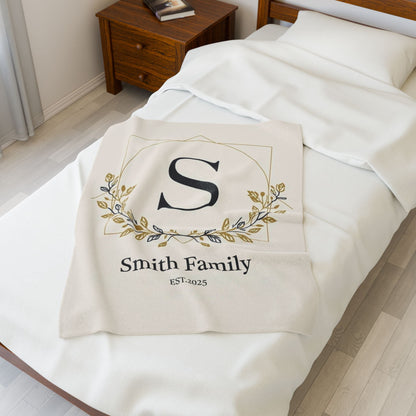 Personalized family monogram fleece blanket with custom name and established date on bed