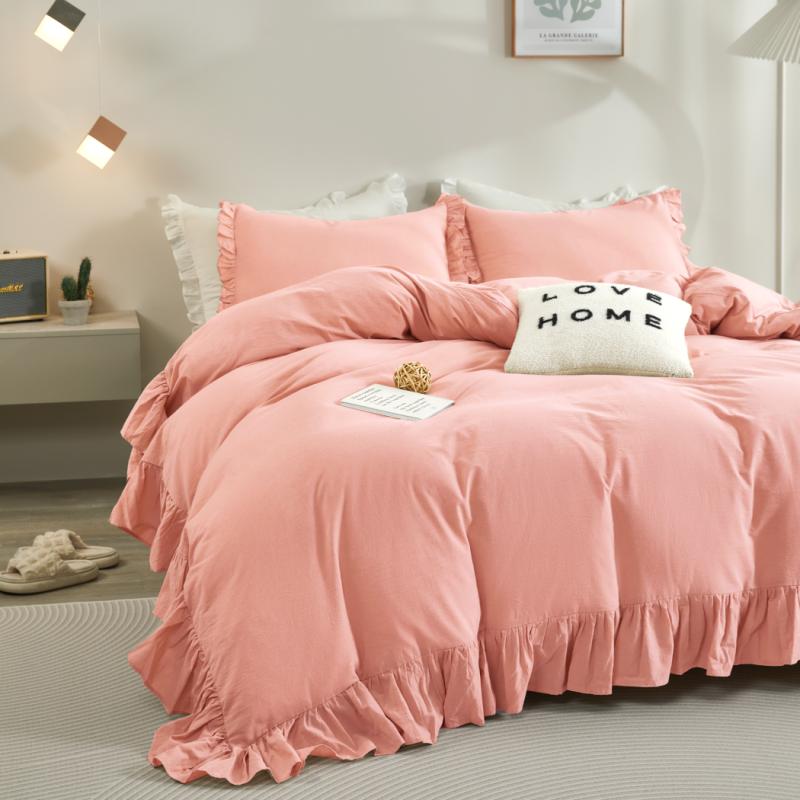 Pink bedding set on a bed in a bedroom with a 'Love Home' pillow.