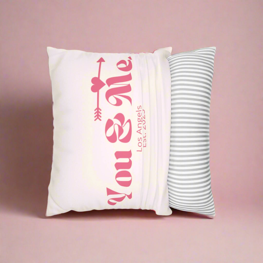 Decorative pillow with 'You & Me' text and another striped pillow on a white background