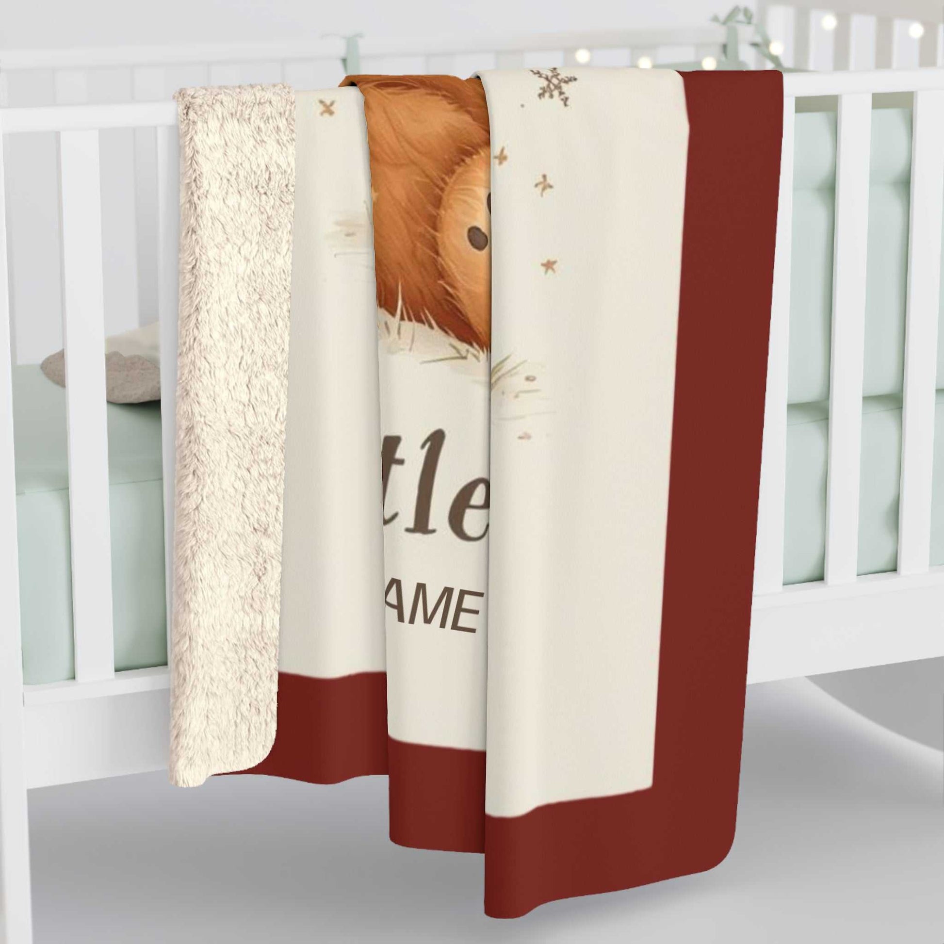 Personalized Mama Bear Christmas blanket with buffalo plaid border and soft fleece material draped over white crib rail