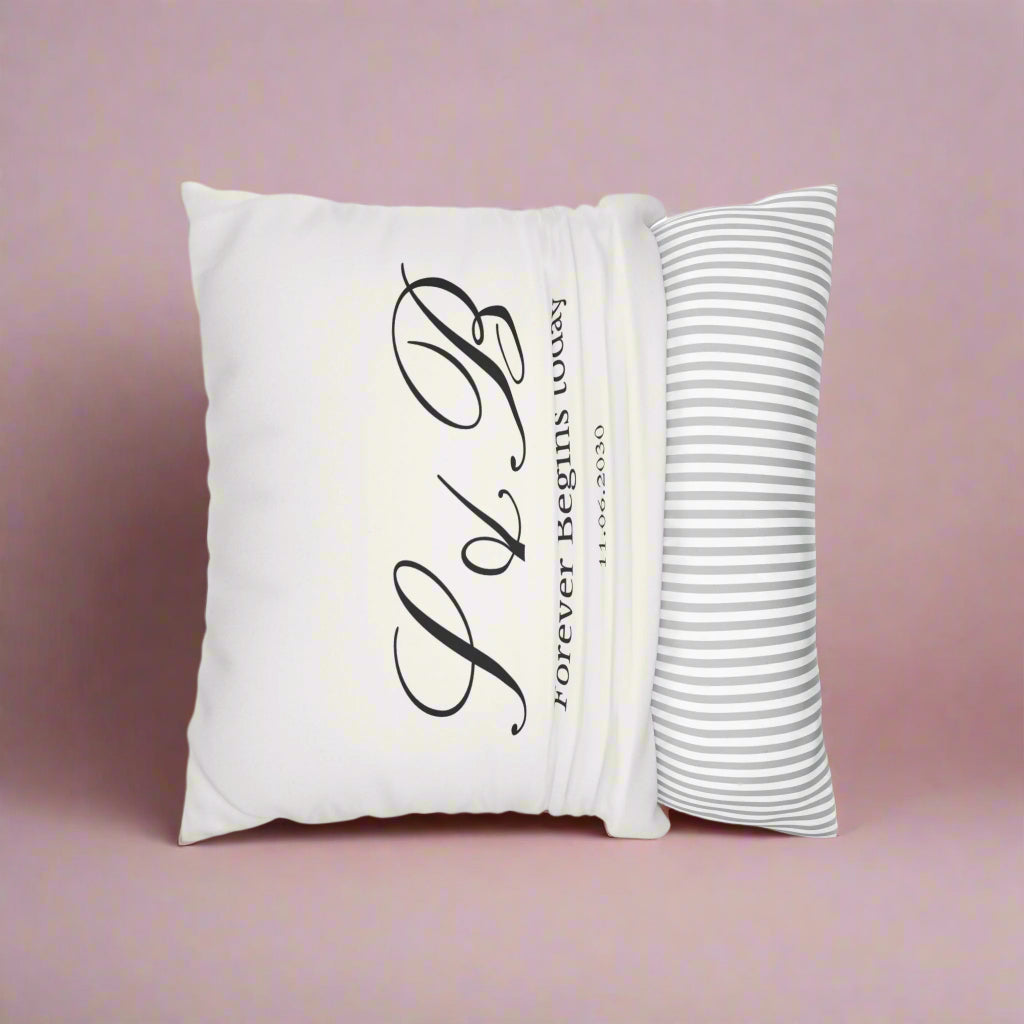White pillow with black text and a striped pillow on a white background