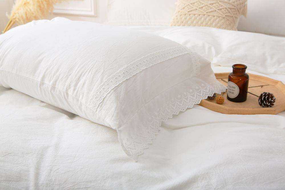 Modern farmhouse duvet cover with white lace trim on a bed.