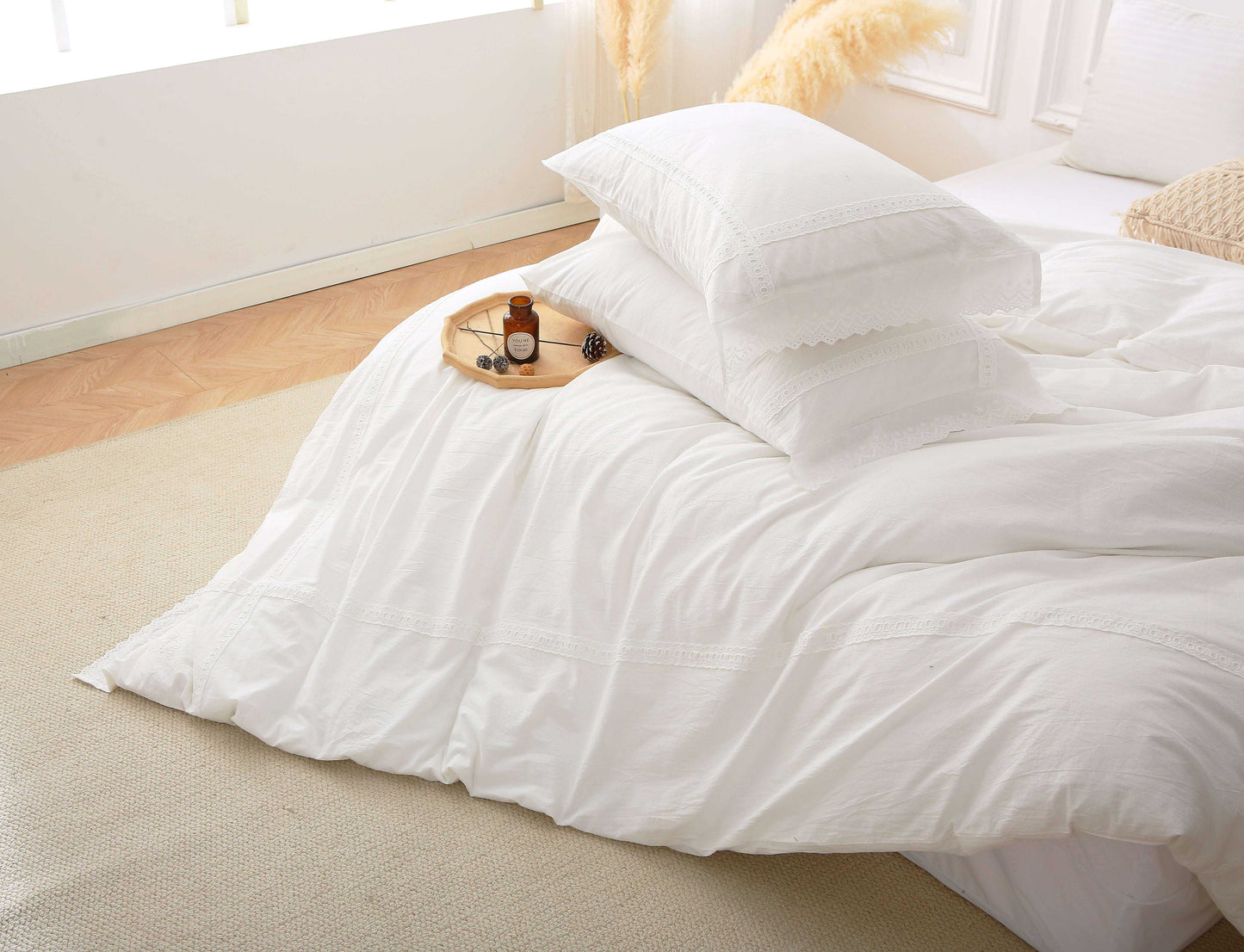 Modern farmhouse duvet cover with white lace trim on a bed.