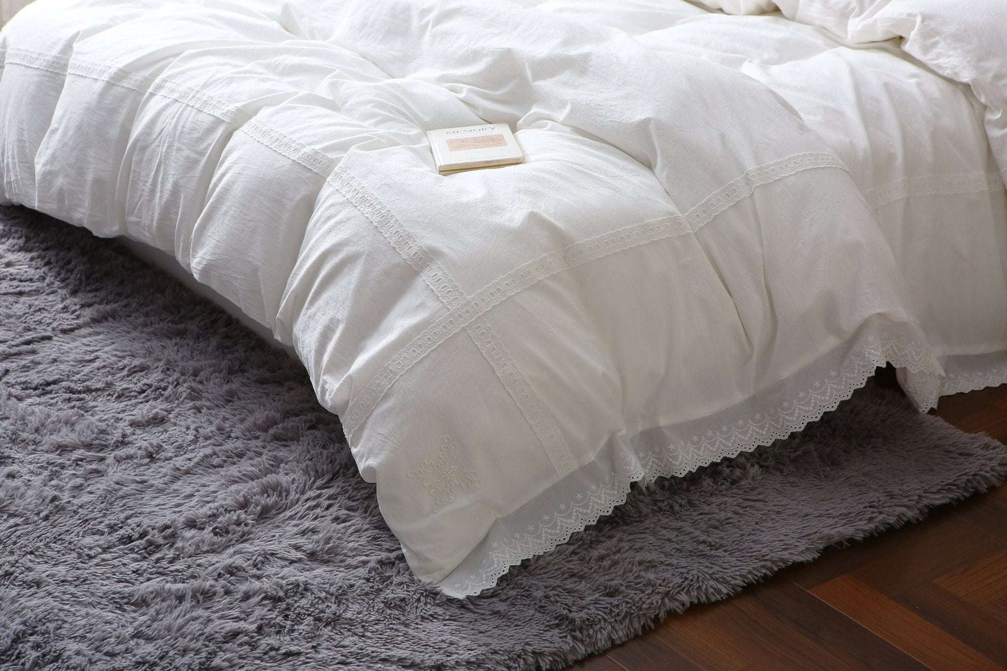 Modern farmhouse duvet cover with white lace trim on a bed.