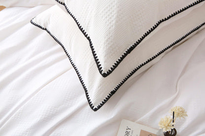 White duvet set with black trim and waffle texture.