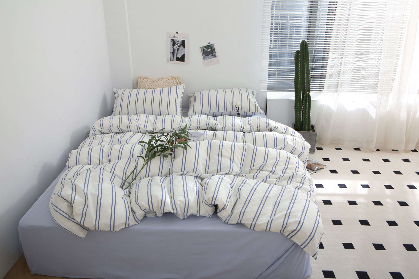 Blue striped bedding set in soft washed cotton on a bed with pillows.