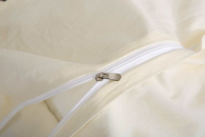 Close-up of cream white vintage duvet cover set with zipper detail.