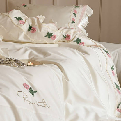 Embroidered duvet cover set with delicate rose designs and elegant ruffled accents in cream satin.