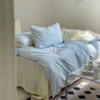 Light blue and crimson bedding set with duvet cover and pillowcases.