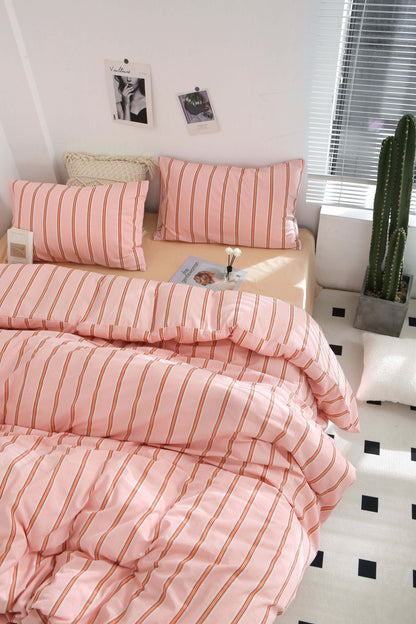 Pink stripe washed cotton bedding set with matching pillowcases on a bed in a bright, modern room