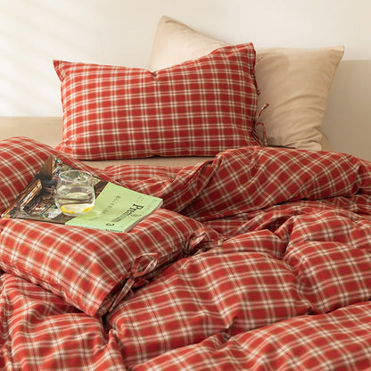 Red plaid duvet set with bow tie accents in a retro indie bedroom.