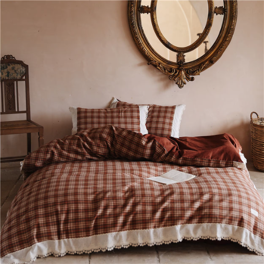 Rustic coquette antique red plaid bedding with white lace trim in a vintage-style bedroom