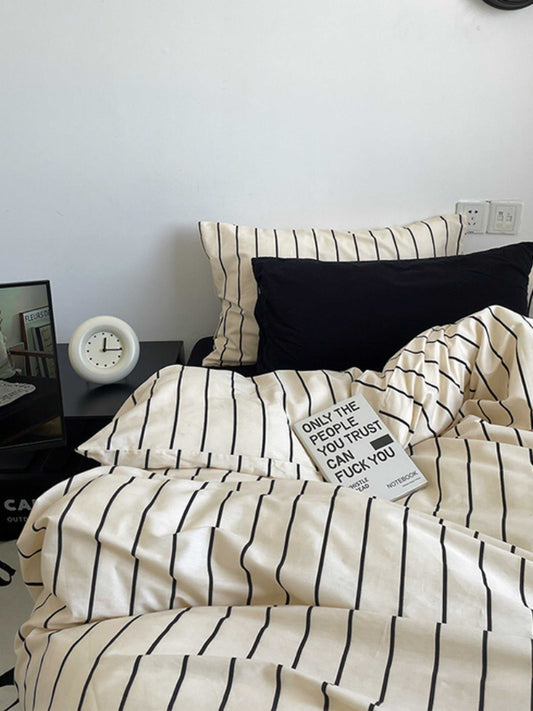 Modern ivory beige stripe cotton duvet cover set with black vertical lines and matching pillowcases on bed