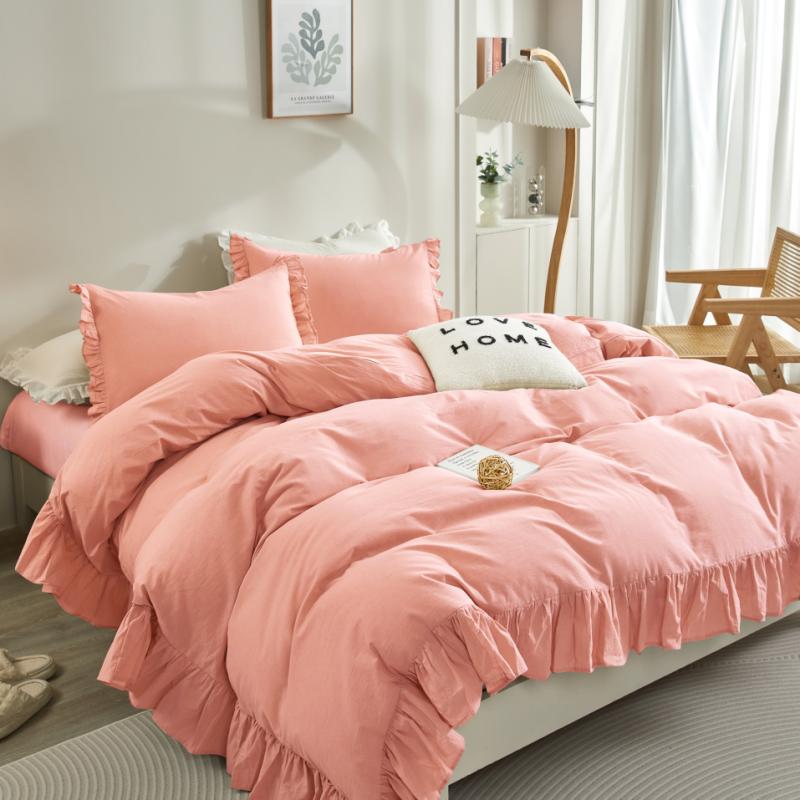 Pink ruffled comforter set on a bed in a bright bedroom