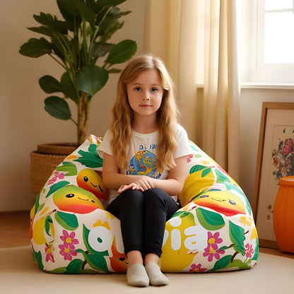 A child sitting on a bean bag chair with a mango fruit theme cover, featuring colorful mangoes and leaves design.