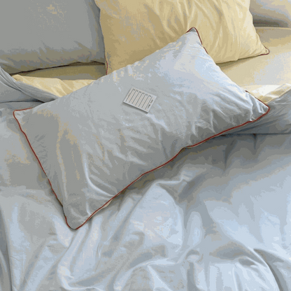 Blue duvet set with orange piping pillow sham on bed
